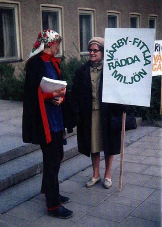 En kvinna med plakat och texten Rädda miljön Vårby-Fittja